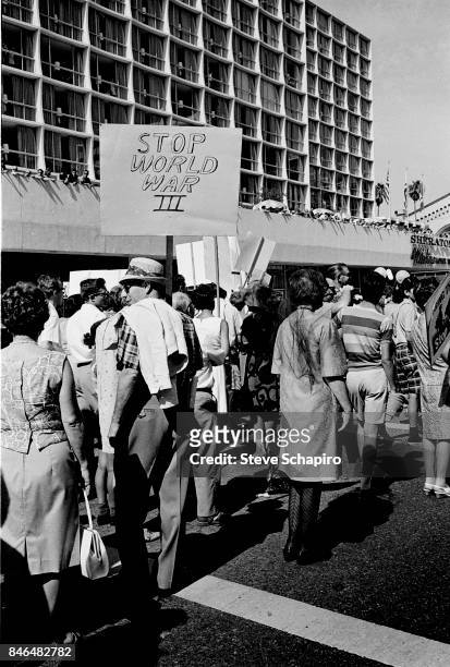 View of protestors during a anti-Vietnan war demonstration on Wilshire Boulevard, Los Angeles, California, 1969. One woman carries a sign that reads...