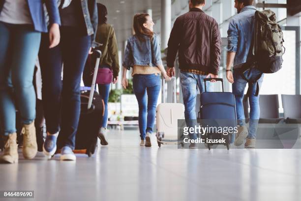 passengers walking in the airport corridor - plane passenger stock pictures, royalty-free photos & images