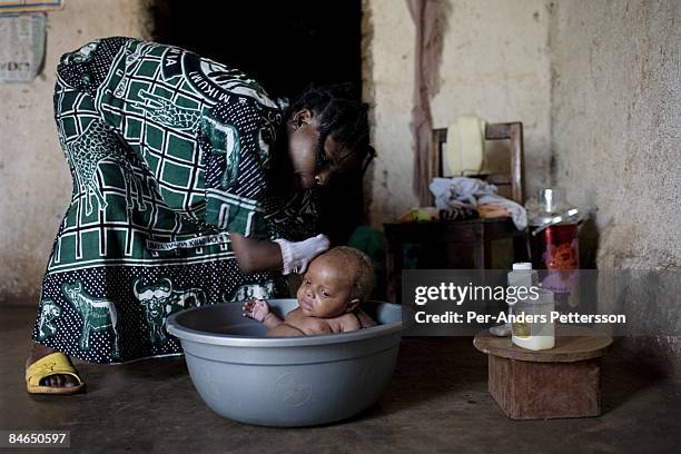 Janette Vumilia, age 30, washes her baby inside her small house on November 1, 2007 Bukavu, DRC. Janette was abducted, held captive and raped by...