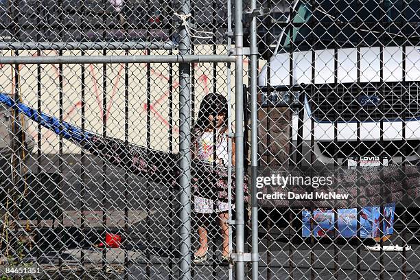 Child watches as a demolition crew tears down the rented house next door that city officials say was used as the headquarters of the notorious...