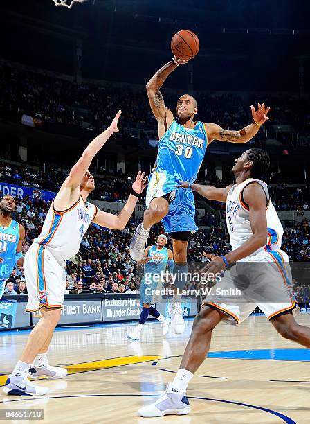 Dahntay Jones of the Denver Nuggets goes to the basket against Nick Collison and Kyle Weaver of the Oklahoma City Thunder at the Ford Center on...