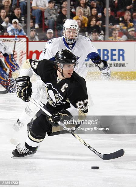 Sidney Crosby of the Pittsburgh Penguins moves the puck in front of Matt Pettinger of the Tampa Bay Lightning on February 4, 2009 at Mellon Arena in...