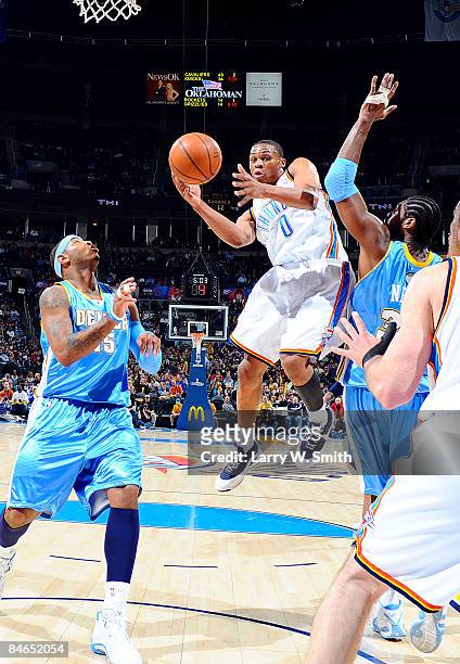 Russell Westbrook of the Oklahoma City Thunder goes to the basket against Carmelo Anthony and Nene of the Denver Nuggets at the Ford Center on...