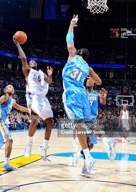 Kyle Weaver of the Oklahoma City Thunder goes to the basket against Nene of the Denver Nuggets at the Ford Center on February 4, 2009 in Oklahoma...