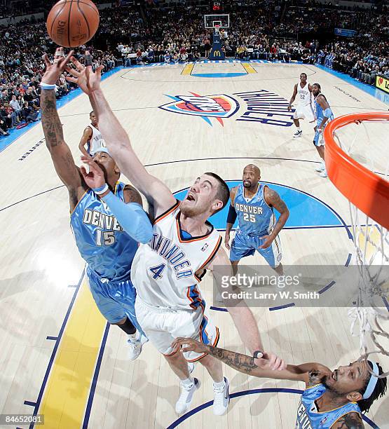 Nick Collison of the Oklahoma City Thunder fights for a rebound against Carmelo Anthony and Renaldo Balkman of the Denver Nuggets at the Ford Center...