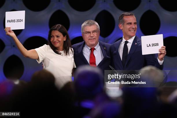 Paris Mayor Anne Hidalgo, IOC President Thomas Bach and Los Angeles Mayor Eric Garcetti react after the confirmation of the tripartite agreement...