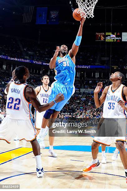 Nene of the Denver Nuggets goes to the basket against Jeff Green and Kevin Durant of the Oklahoma City Thunder at the Ford Center on February 4, 2009...