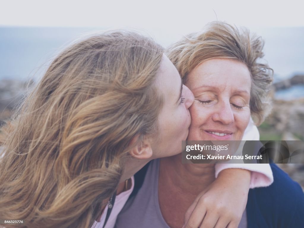 Daughter kissing her mother outdoors