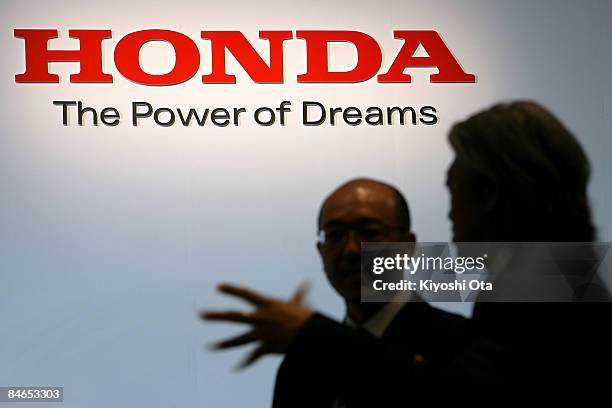 Members of staff are silhouetted on a wall with the logo of Honda Motor Co. Ltd. During a press conference to introduce their newest hybrid car, the...