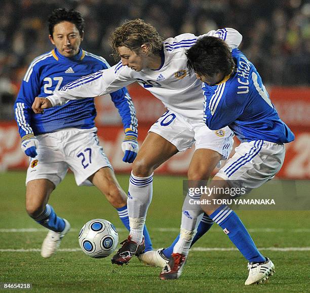 Finland's Roni Porokara vies for the ball with Japan's Atsuto Uchida and Hideo Hashimoto during their friendly football match in Tokyo on February 4,...