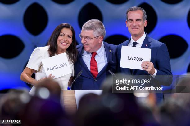 International Olympic Committee President Thomas Bach poses for pictures with Paris Mayor Anne Hidalgo and Los Angeles Mayor Eric Garcetti during the...