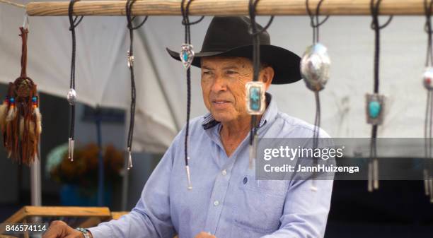 santa fe, nm, usa: mann im stand verkauft bolo ties auf fiesta - wildwestkrawatte stock-fotos und bilder