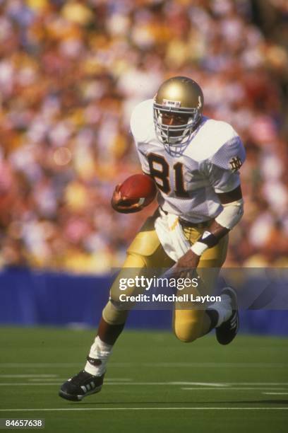 Tim Brown of the Notre Dame Fighting Irish runs with the ball a college football game against the Michigan Wolverines o nSeptember 1, 1987 at Notre...