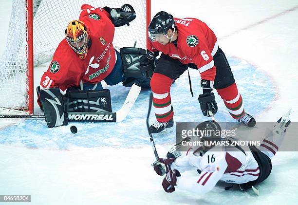 Aleksejs Sirokovs of Latvia vies with goalkeeper Levente Szuper and Viktor Tokaji of Hungary in their Olympic Qualification tournament group F ice...