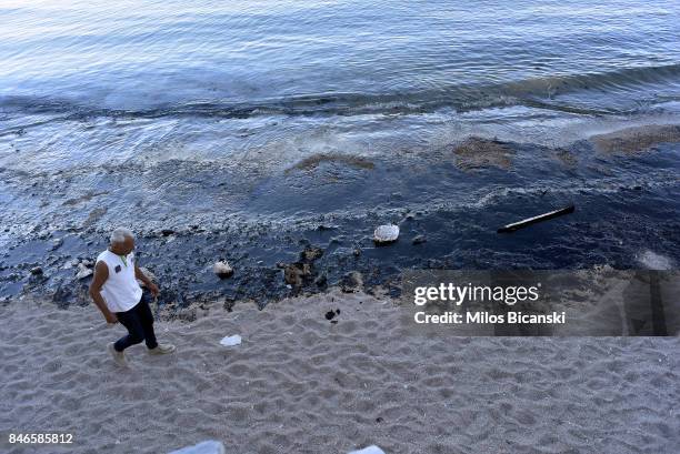 Man walks along a polluted beach on the coast of Salamis Island on September 13, 2017 in Salamis, Greece. The small tanker 'Agia Zoni II' sank on...