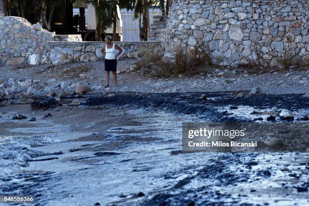 Woman inspects a beach on the coast of Salamis Island which has been polluted with oil on September 13, 2017 in Salamis, Greece. The small tanker...