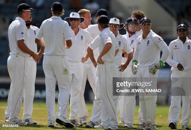 England's cricketer Andrew Flintoff celebrates with teammates after dismissing West Indies batsman Devon Smith during the second day of the first...