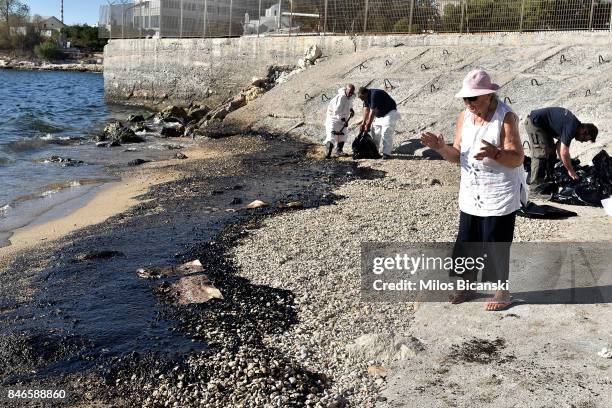 People begin to clear oil from a polluted beach on the coast of Salamis Island on September 13, 2017 in Salamis, Greece. The small tanker 'Agia Zoni...