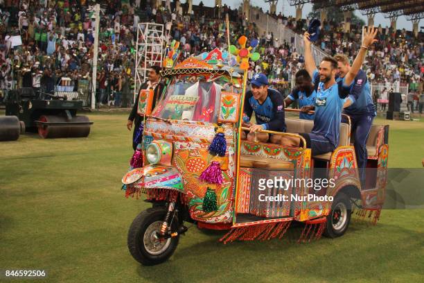 World-XI cricket team players waving the spectators while enjoying a ride on traditional tri-cycle rickshaw at Gaddafi Cricket Stadium in Lahore on...