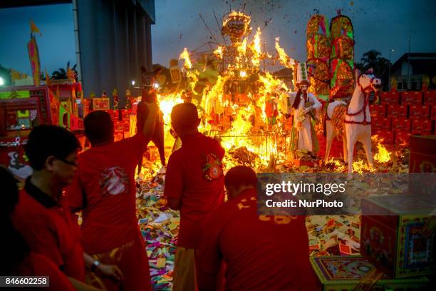 Ethnic Chinese in Malaysia throw a paper offerings a special prayer in front of God of Ghosts paper statue during the Hungry Ghost Festival in Teluk...