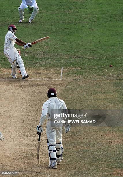 West Indies cricket team captain Chris Gayle looks on as batsman Ramnaresh Sarwan hits the ball during the second day of the first Test match between...