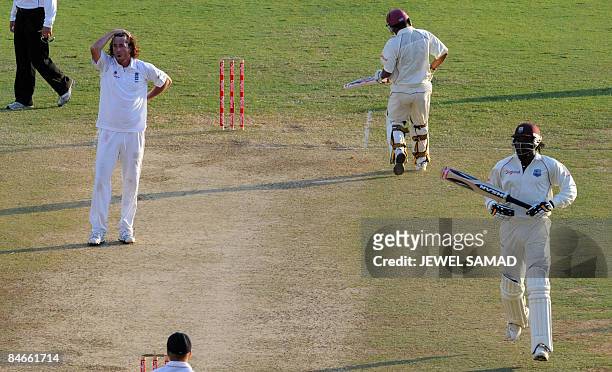 West Indies cricketer Ramnaresh Sarwan and captain Chris Gayle take a run as England's bowler Ryan Sidebottom reacts during the second day of the...