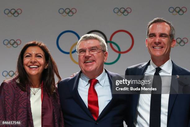 Anne Hidalgo, Thomas Bach and Eric Garcetti pose for pictures during a joint press conference between IOC, Paris 2024 and LA2028 during the131th IOC...