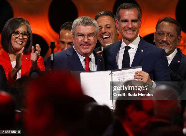 President Thomas Bach and LA Mayor Eric Garcetti show the signed agreement during a joint press conference between IOC, Paris 2024 and LA2028 during...
