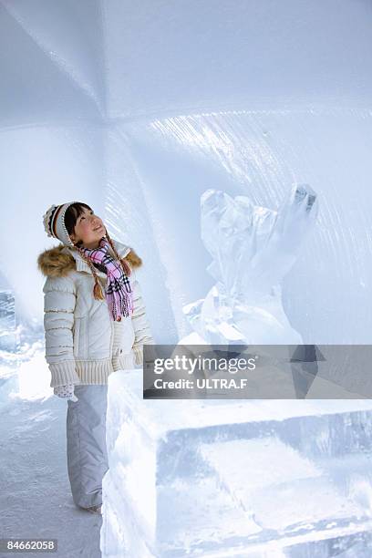 a girl is looking at the wall of ice. - ice sculpture stock-fotos und bilder