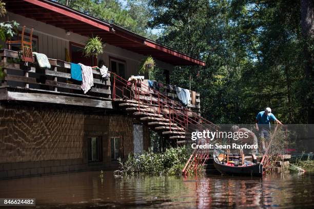 Homeowner Mike Riley, left, gets a hand from Brenda Smith as floodwaters from Hurricane Irma recede Sept. 13, 2017 in Middleburg, Florida, United...
