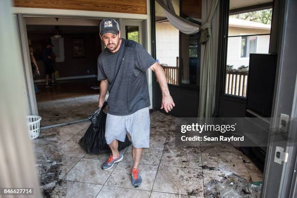 David Dionne helps to clean up as floodwaters from Hurricane Irma recede September 13, 2017 in Middleburg, Florida. Floodwaters in town from the...