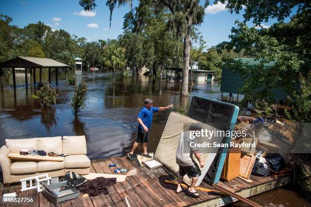 Marc St. Peter, left, and Chris Wisor lend a hand cleaning up as floodwaters from Hurricane Irma recede September 13, 2017 in Middleburg, Florida....