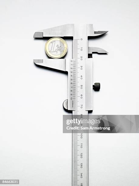 euro coin measured by calipers. - calibrador fotografías e imágenes de stock