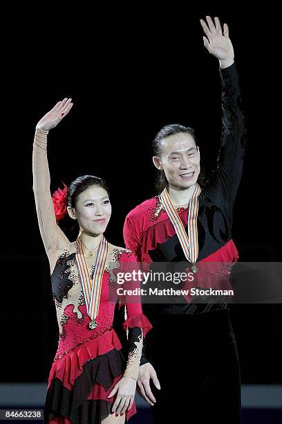 Qing Pang and Jian Tong of China acknowledge the crowd from the winners podium after the Pairs Free Skate during the ISU Four Continents Figure...