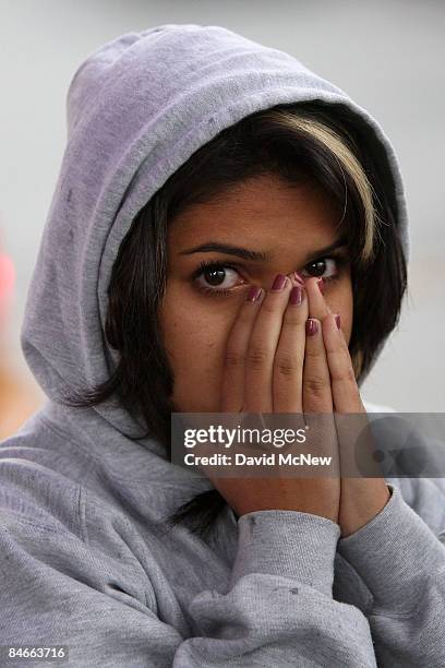 Woman puts her hands over her mouth as she watches the fate of her father as Sheriff Deputies makes arrests while detaining about 52 predominantly...