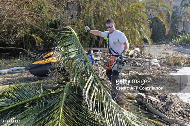 Michael Bernard with Monroe County Fire Rescue trims a tree from a road way in a neighborhood in Cudjoe Key, Florida, September 13, 2017. The Florida...