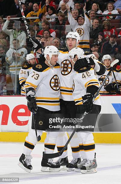 Zdeno Chara of the Boston Bruins celebrates his second period goal against the Ottawa Senators with teammates Michael Ryder and David Krejci at...