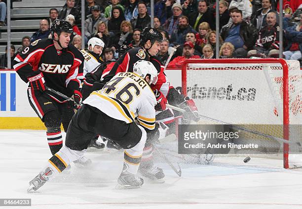 Filip Kuba of the Ottawa Senators deflects a shot by David Krejci of the Boston Bruins away from an open net as Brendan Bell of the Ottawa Senators...