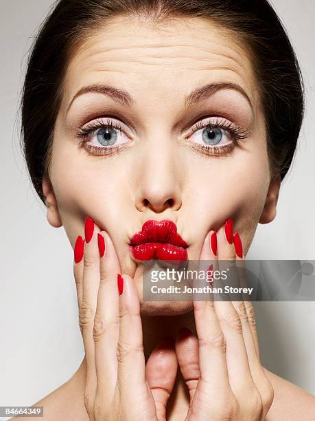 beauty squeezing cheeks red nails - woman mouth stock pictures, royalty-free photos & images
