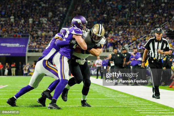 Andrew Sendejo and Harrison Smith of the Minnesota Vikings push Coby Fleener of the New Orleans Saints out of bounds during the game on September 11,...