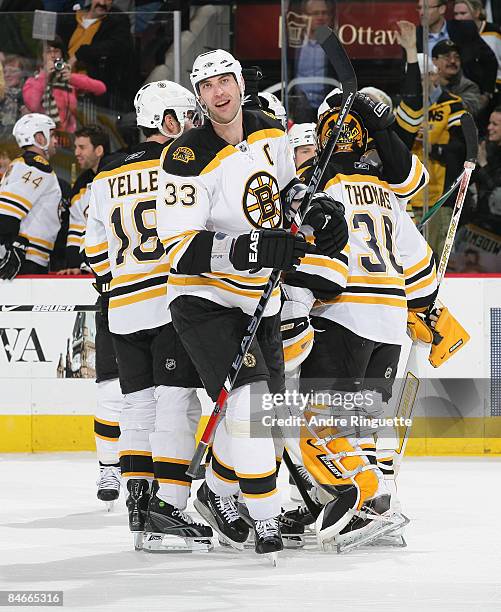 Zdeno Chara of the Boston Bruins celebrates his team's shoot out win over the Ottawa Senators with Stephane Yelle and Tim Thomas of the Ottawa...