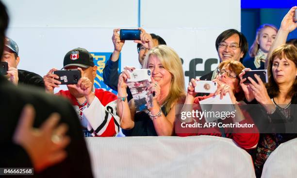 Fans take photos as The Tragically Hip poses on the red carpet during the premiere of the film 'Long Time Running' at the Toronto International Film...