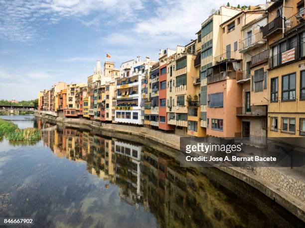 coloured houses reflected in the water of the river onyar river in girona, catalonia, spain. - rivière onyar photos et images de collection