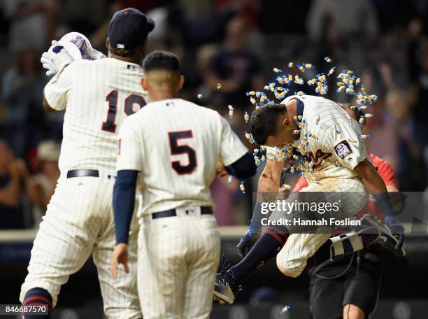 Eduardo Escobar of the Minnesota Twins looks on as teammate Kennys Vargas congratulates Eddie Rosario on hitting a walk-off two-run home run against...