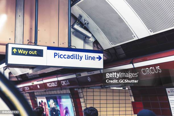 melden sie regie menschen gegenüber der piccadilly line an der piccadilly circus station - piccadilly stock-fotos und bilder