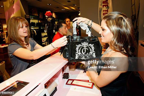 Juliane Zubia purchases items from cashier Randi Walsh during the grand opening of a Juicy Couture retail store at The Forum Shops at Caesars Palace...
