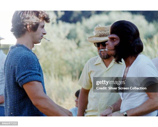 American actors Roddy McDowall as Galen and James Naughton as Pete Burke take a break on the set of science fiction television series 'Planet of the...