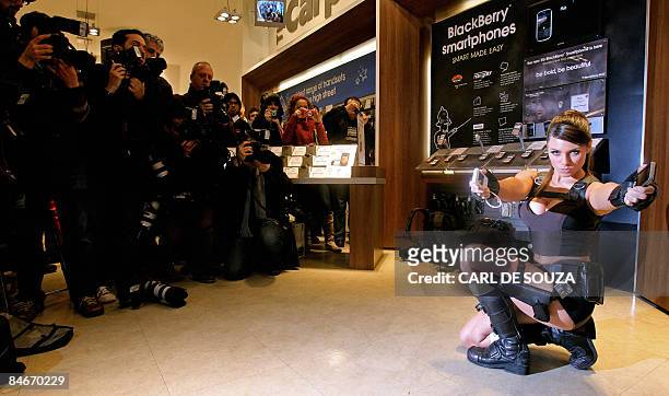Model Alison Carroll poses with mobile phones as film and computer games character Lara Croft during a photocall in London on February 6, 2009. The...