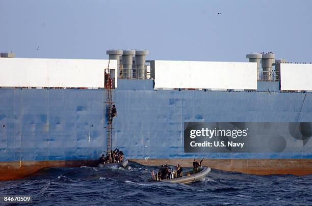 In this handout from the U.S. Navy, Sailors from the Norfolk-based destroyer USS Mason climb aboard Ukrainian Ship MV Faina to conduct a health and...