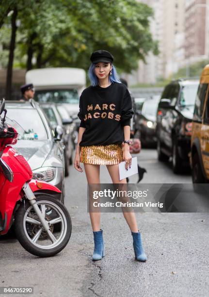 Irene Kim wearing Marc Jacobs sweater, flat cap golden skirt seen in the streets of Manhattan outside Marc Jacobs during New York Fashion Week on...